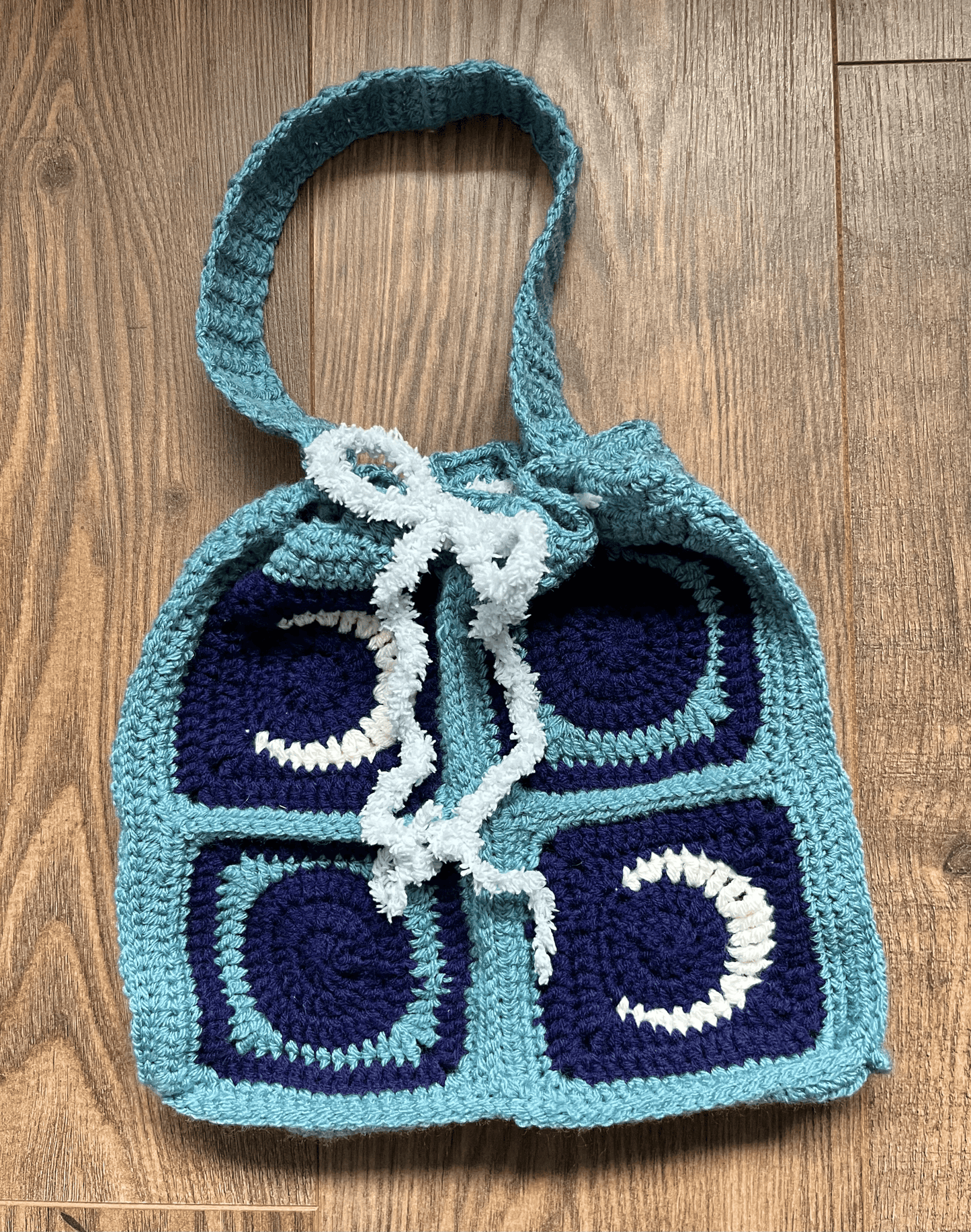 Handmade New Moon crochet tote bag showing celestial design and fastening