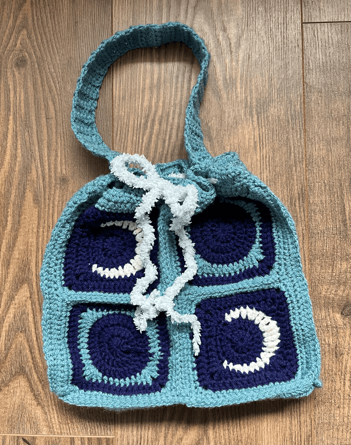 Handmade New Moon crochet tote bag showing celestial design and fastening