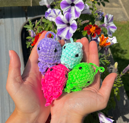 Four handmade crochet jellyfish keyrings in luminescent purple, blue, green and pink