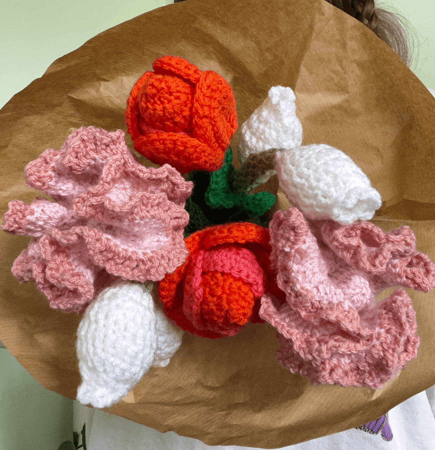 Close-up of handmade crochet tulips, carnations and lily of the valley flowers in a spring floral arrangement