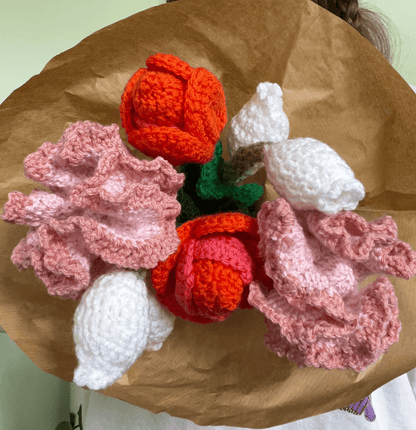 Close-up of handmade crochet tulips, carnations and lily of the valley flowers in a spring floral arrangement
